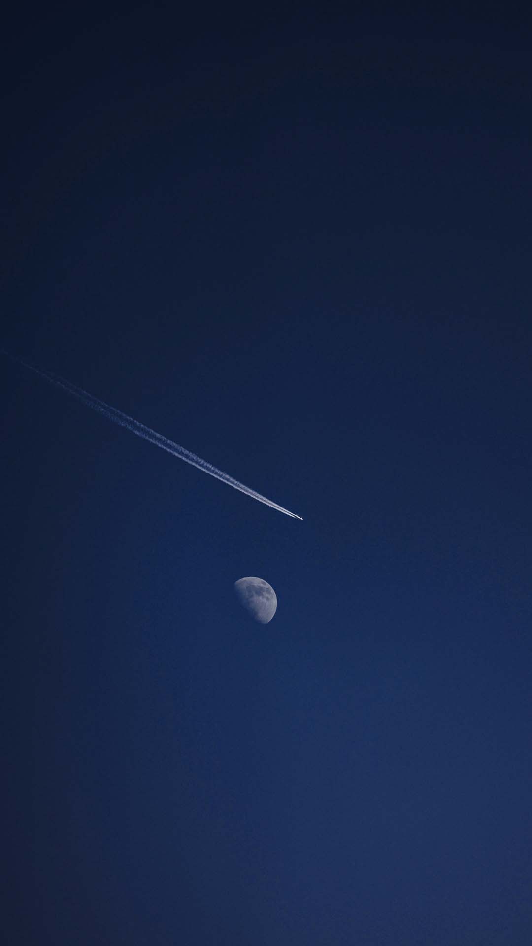 An aircraft cruising in front of the moon